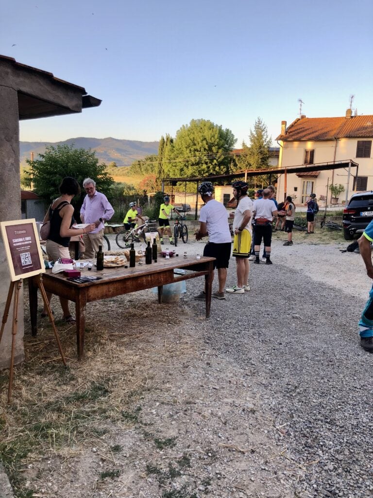 banco con il vino Fralupaia, ciclisti che assaggiano vino e olio